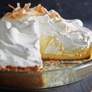 Coconut-Lime Cream Pie in a glass dish against a dark background
