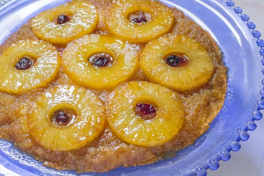 pineapple upside down cake with dried cranberries on a glass plate