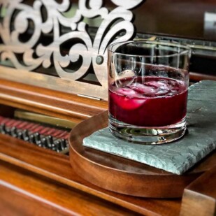 Ginger Beet Old-Fashioned in a clear glass on a piece of slate