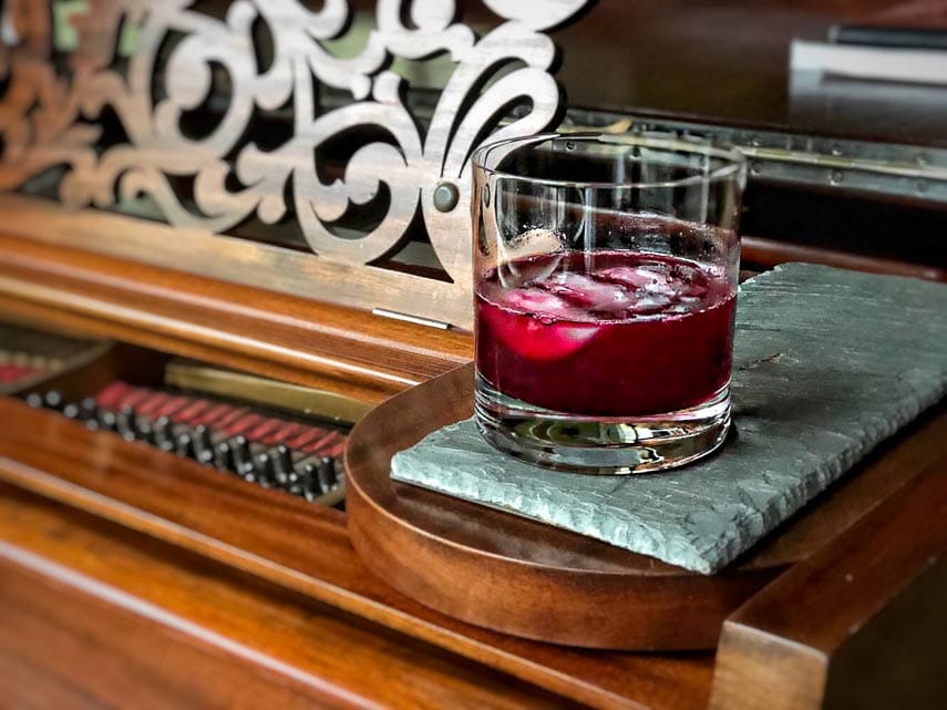 Ginger Beet Old-Fashioned in a clear glass on a piece of slate
