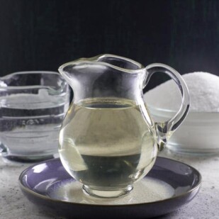 Simple Syrup in clear glass pitcher on blue ceramic dish
