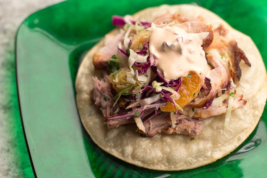 Shredded Dry Rubbed Slow-Roasted Pork on fried corn tortilla with slaw and low FODMAP chipotle mayonnaise on a green glass plate 