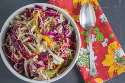 Light & Crunchy Carolina Coleslaw in a white bowl with serving spoon alongside