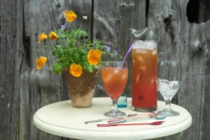 Strawberry Arnold Palmer in glass pitcher and glass against barn board