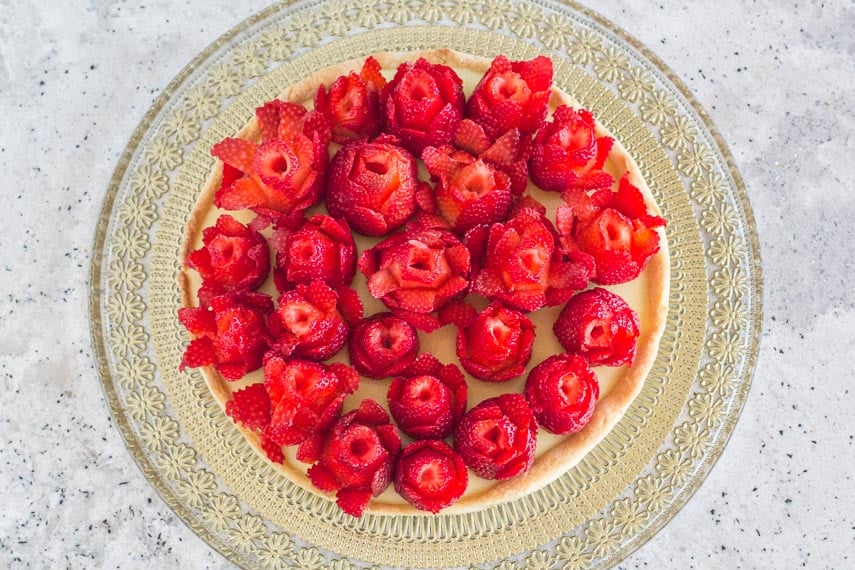 Strawberry rose tart with pastry cream and tart crust on gold glass platter