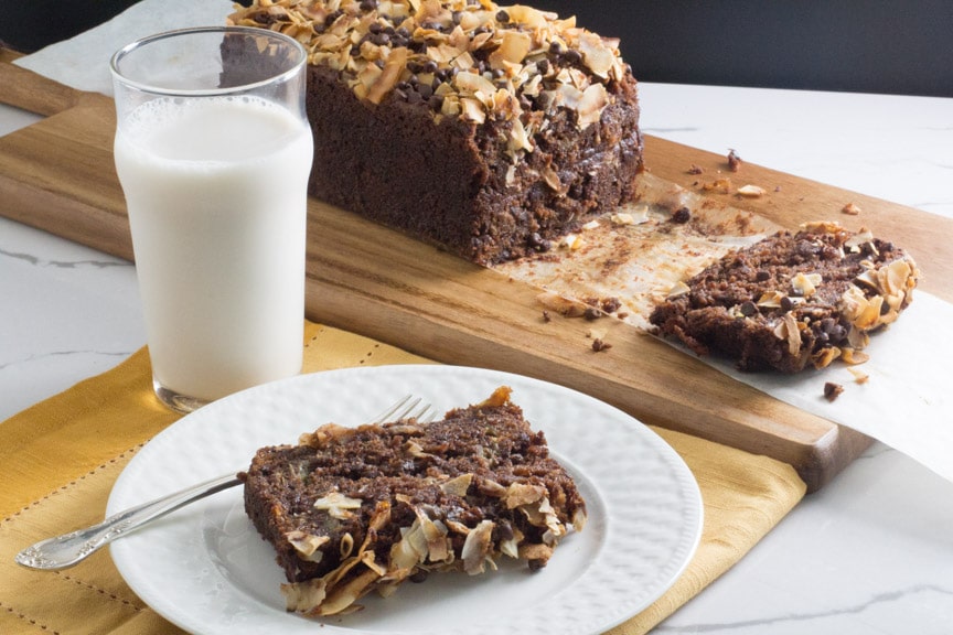 chocolate coconut banana bread in pan showing off its decadent coconut chocolate topping