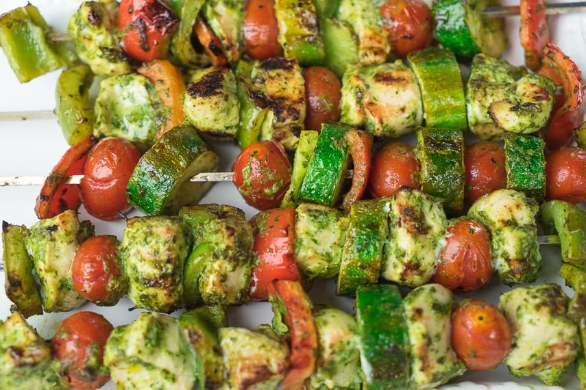 closeup of grilled chicken and vegetable kebobs on a white platter