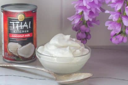 coconut whipped cream in gladd bowl with spoon and can of coconut milk