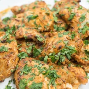 platter of spiced yogurt grilled chicken garnished with cilantro