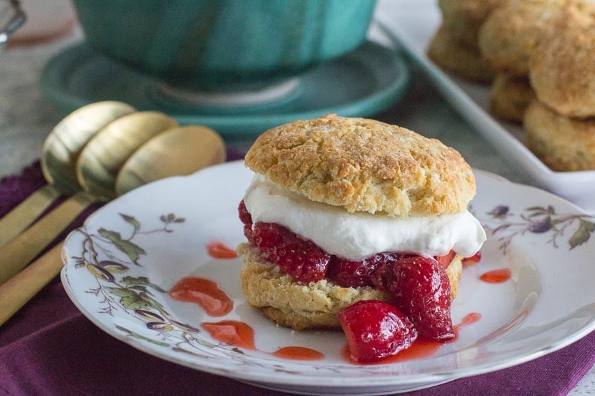 strawberry shortcake on a white plate with gold spoons alongside-2