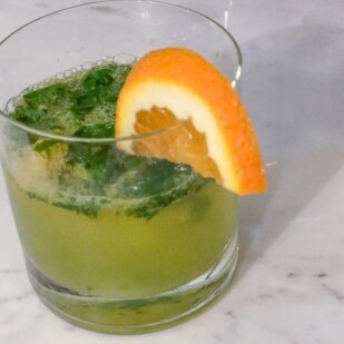 Basil orange smash in a short glass with orange wedge