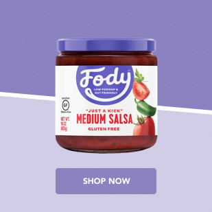 Fody container of medium salsa with images of sliced tomatoes, jalapeños, and limes on a purple background