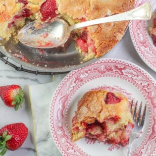 overhead image of strawberry yogurt skillet cake on pink plate and in skillet with serving spoon