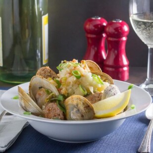 roast clams and sausage with mashed potatoes in white bowl