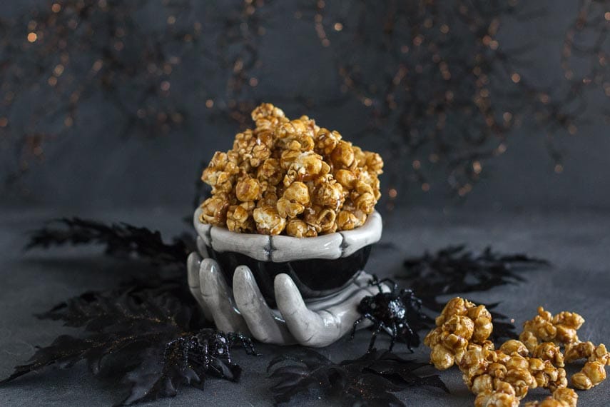 gingerbread caramel crunch popcorn in ceramic skeleton bowl