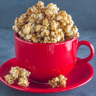 gingerbread caramel crunch popcorn in red ceramic mug on saucer