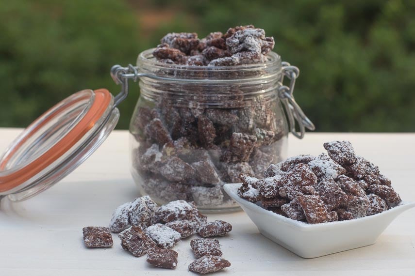 muddy buddies in glass jar and in white dish on white surface