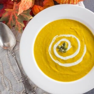overhead image of spicy smoky pumpkin soup in white bowl