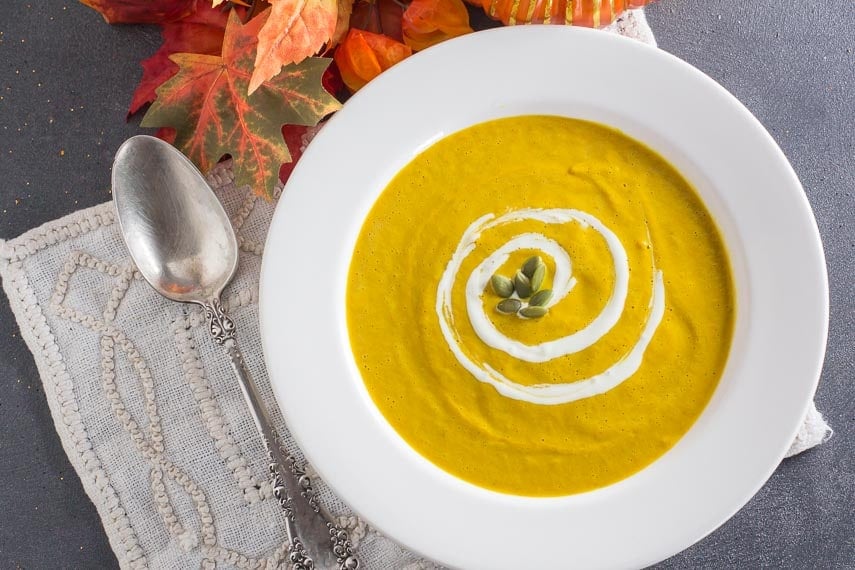 overhead image of spicy smoky pumpkin soup in white bowl