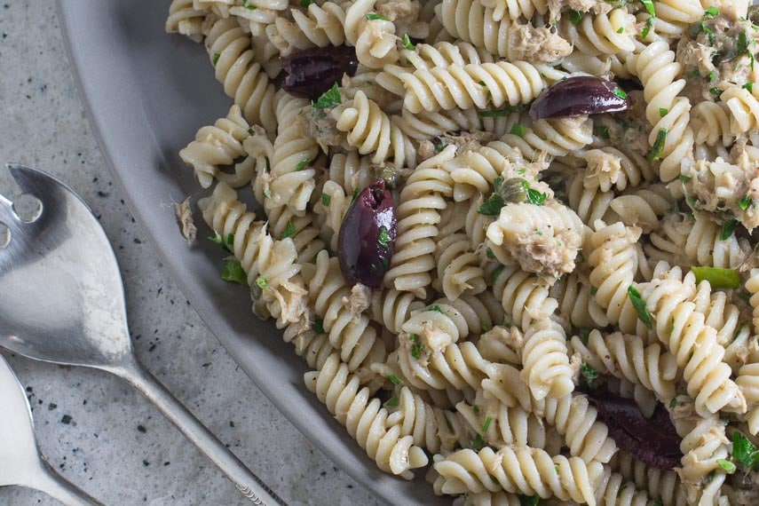 Low FODMAP Pantry Pasta with Tuna, Lemon & Olives on a gray platter