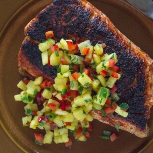 Blackened Salmon with low FODMAP sweet & spicy dry rub and low FODMAP pineapple salsa on a brown plate