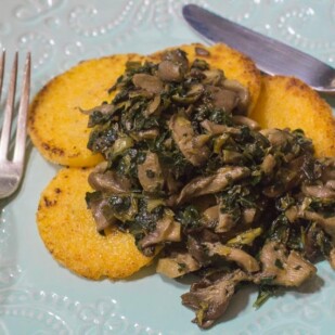 Low FODMAP Polenta with Sautéed Mushrooms & Kale on an aqua plate
