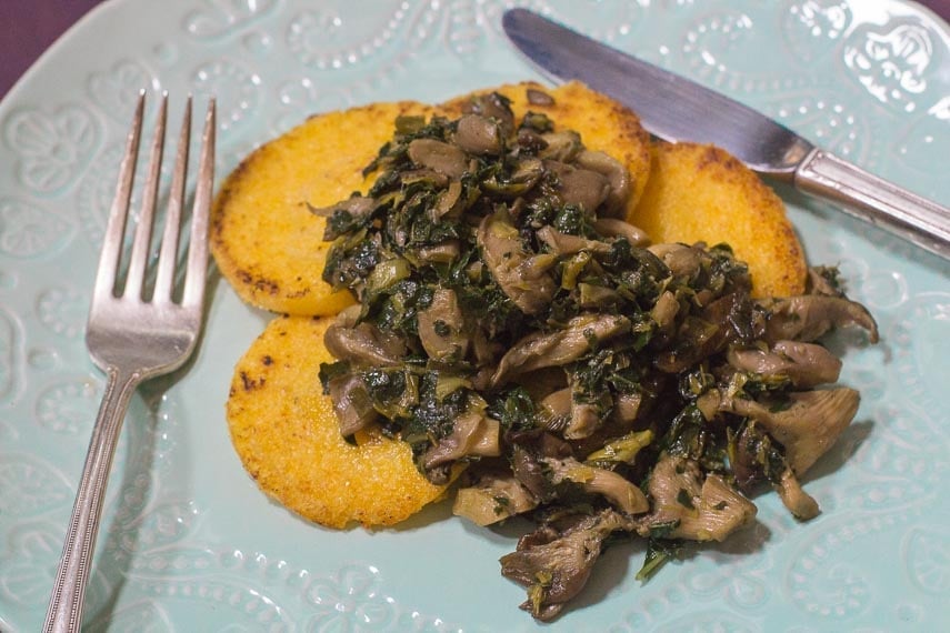 Low FODMAP Polenta with Sautéed Mushrooms & Kale on an aqua plate