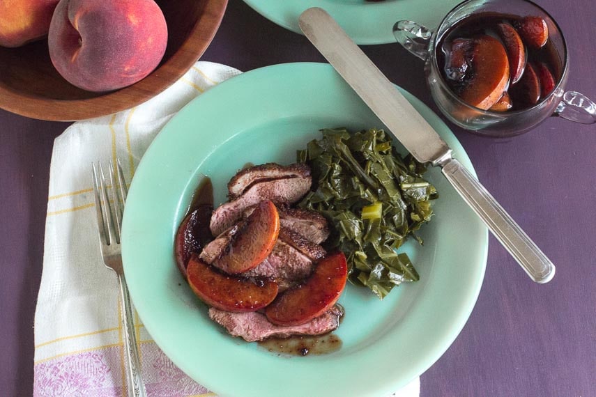 overhead image of Low FODMAP Duck Breasts with Peaches & Red Wine on a green plate