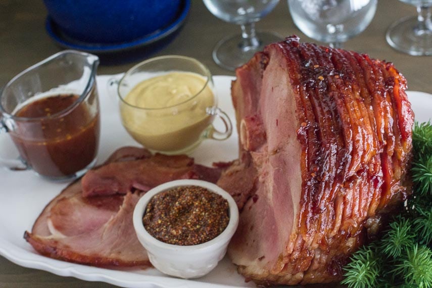 Low FODMAP Cranberry Hot Pepper Glazed Ham on oval white platter with pan juices and assorted mustard-2