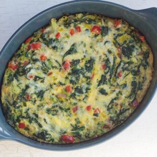 Low FODMAP Quinoa, Greens & Bell Pepper Puff overhead image in blue casserole