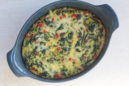 Low FODMAP Quinoa, Greens & Bell Pepper Puff overhead image in blue casserole