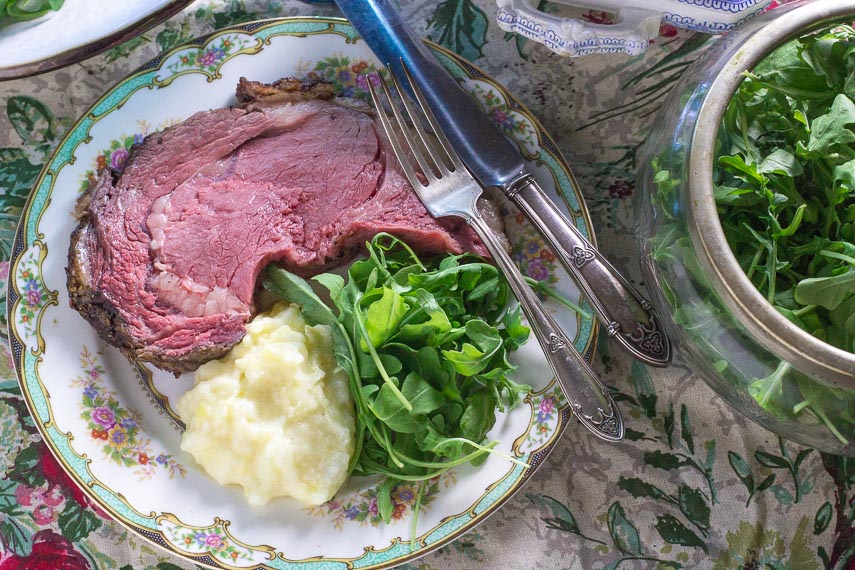 Low FODMAP Standing Rib Roast with a Dijon Herb Crust plated with arugula salad and mashed potatoes