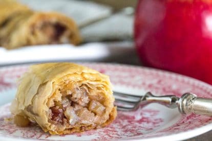 closeup of low FODMAP apple strudel on a pink and white plate with a silver fork