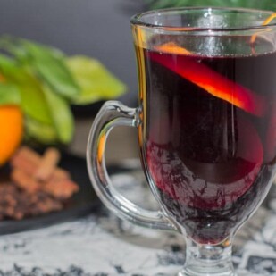closeup of low fodmap mulled wine with orange zest on rim of clear glass mug
