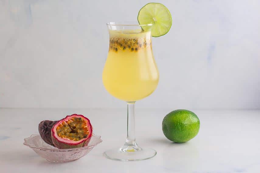 horizontal image of passion for coconut drink with a lime and passion fruit in background