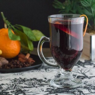 image of low fodmap mulled wine with orange zest on rim of clear glass mug