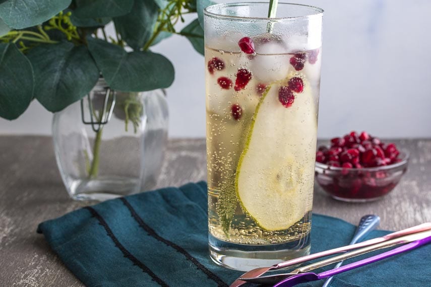 low fodmap ginger pomegranate pear sparkler in tall clear glass and stirrer