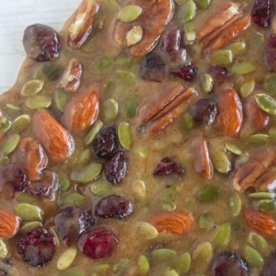 slab of Low FODMAP Spiced Fruit & Nut brittle on white painted wood surface