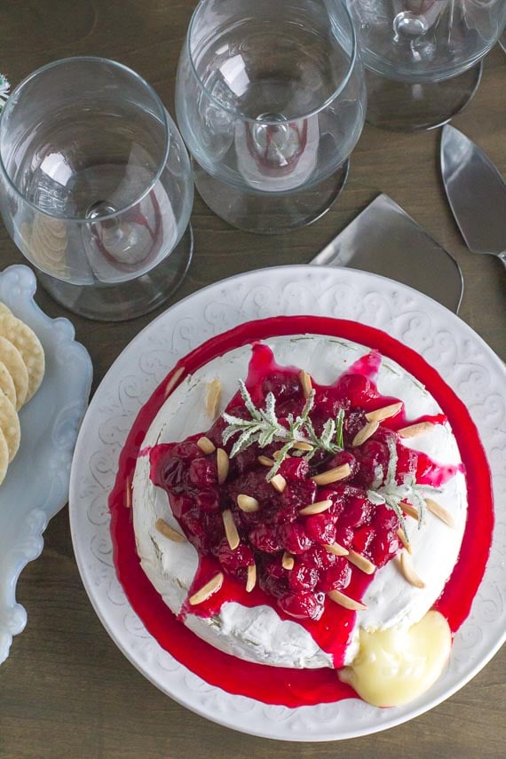 vertical image of baked brie with cranberries