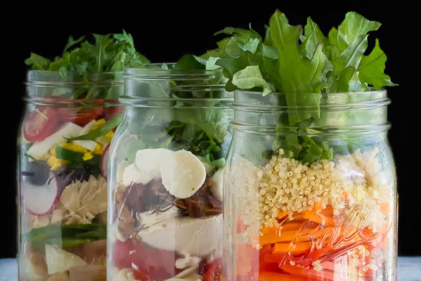 Low FODMAP Mason jar Salads in jars, vertical image, against black background