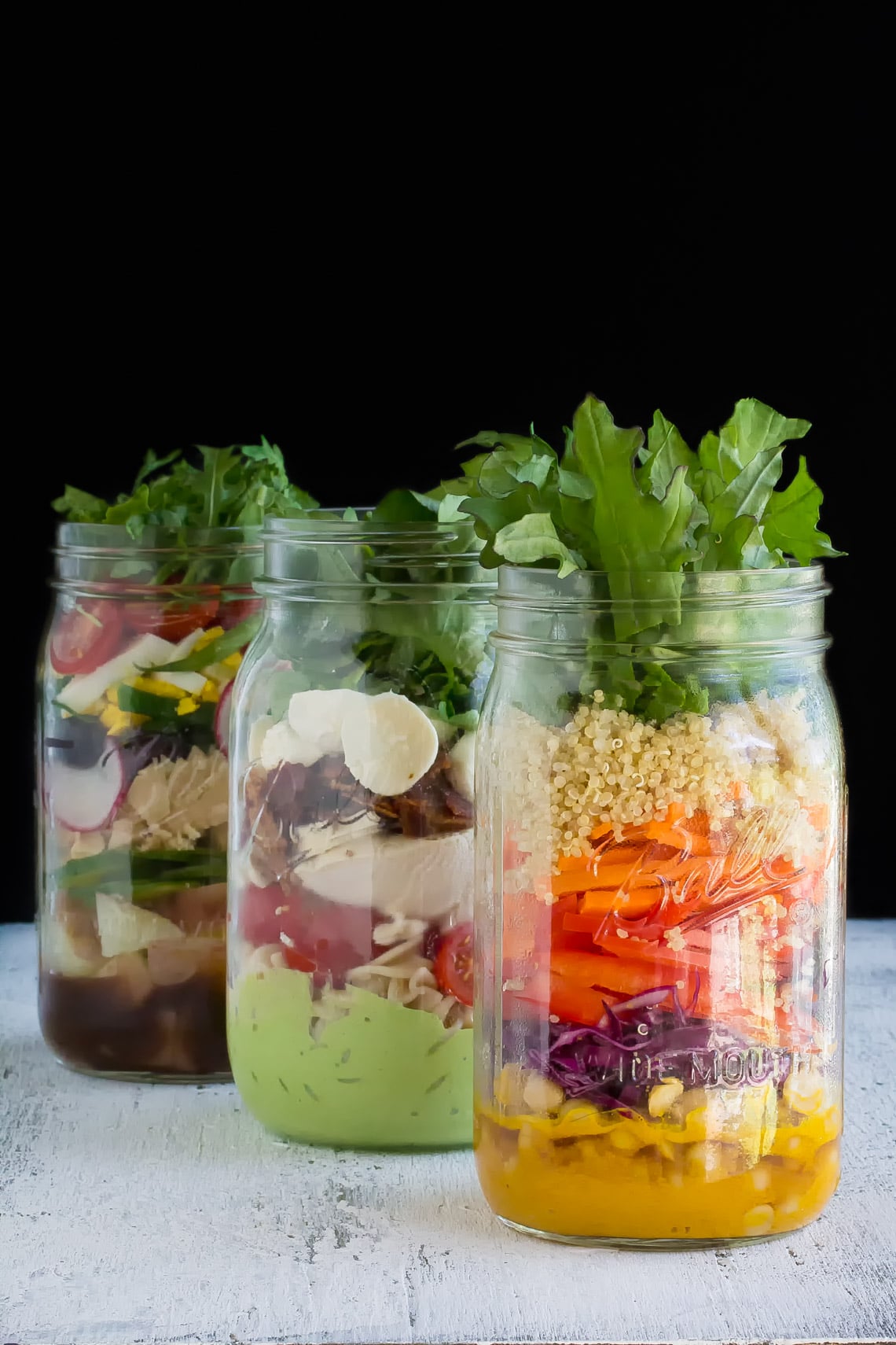 Low FODMAP Mason jar Salads in jars, vertical image, against black background
