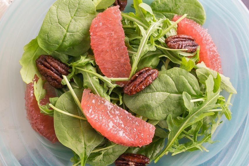 Greens with Grapefruit and Candied pecans on a blue glass plate