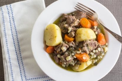 Low FODMAP Irish Lamb Stew with barley in white bowl on taupe tablecloth