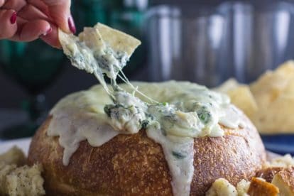 cheesy low FODMAP hot spinach artichoke dip in bread bowl with corn chip dipper_