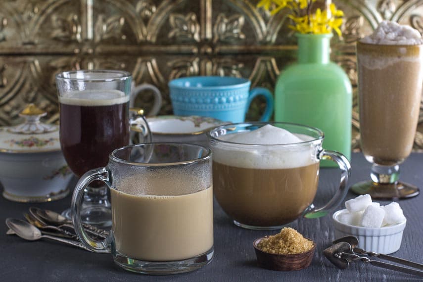 coffee drinks with lumps of sugar and raw sugar on the foreground