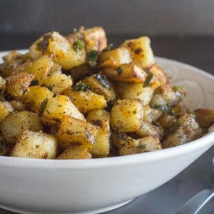 white bowl of low FODMAP home fries with serving spoon