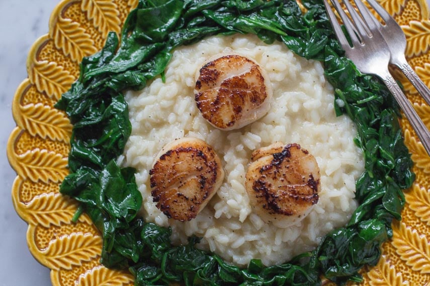 lemon pepper risotto with pan seared scallops on yellow plate