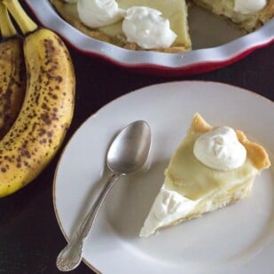 slice of low FODMAP banana cream pie on white plate with spoon