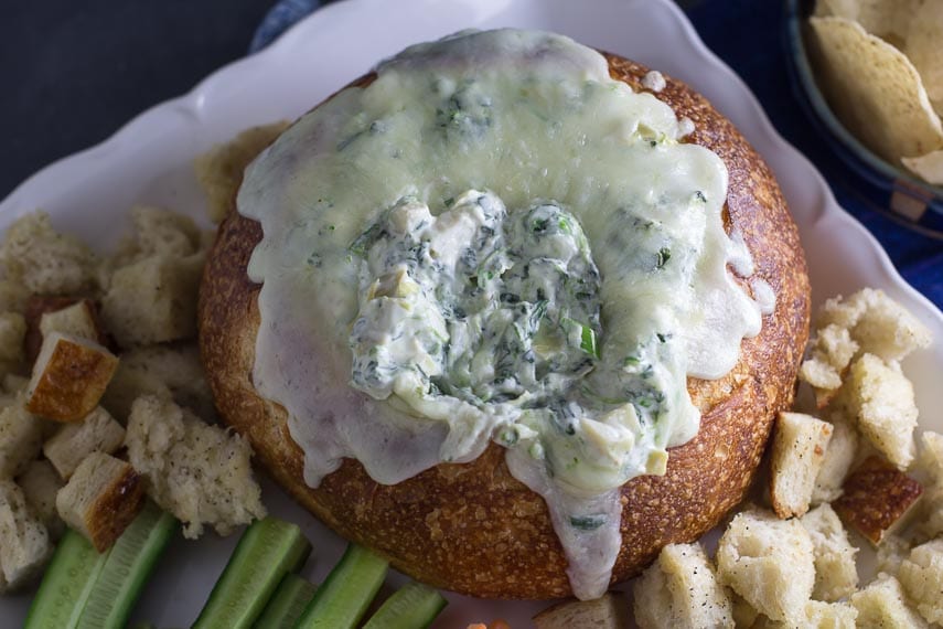 top view of low FODMAP hot spinach artichoke dip in a bread bowl