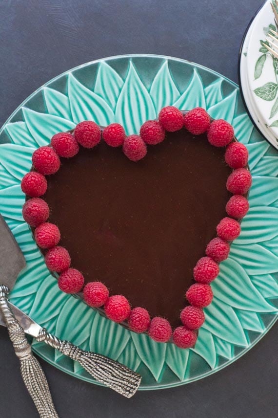vertical of low FODMAP Raspberry Chocolate Truffle Cake on green platter